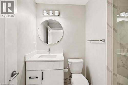 Contemporary bathroom featuring a white vanity with quartz-style countertop, undermount sink, and black hardware - 131 St George Street, Kitchener, ON 