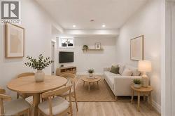 Open-concept living space with light wood-finish flooring, recessed lighting, and a window - 