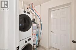 Dedicated laundry area featuring a stacked washer and dryer, adjacent to a utility door - 