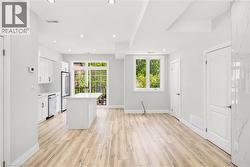 Expansive open-concept living area featuring wood-finish flooring and recessed lighting - 