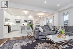 Open-concept living area with wood-finish flooring extending into the living room - 