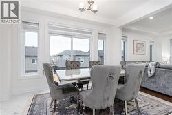 Dining area featuring large windows, crown molding, a modern chandelier, an open concept design, and white tile flooring - 