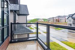 Private balcony featuring a concrete surface and black framed glass railing - 