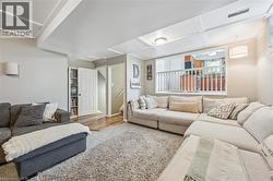 Spacious living area featuring a coffered ceiling and recessed lighting - 