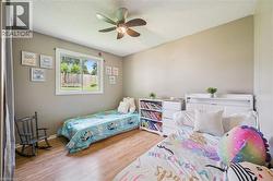 Interior room featuring wood-finish flooring, neutral wall tones, and a ceiling fan with integrated lighting - 