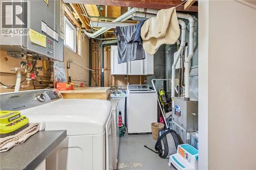 Dedicated utility space featuring laundry appliances, exposed wood beams, and a window for natural light - 24 Byton Lane, Cambridge, ON 