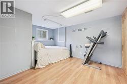 Room featuring wood-finish flooring, a double-pane window, and light blue wall tones - 