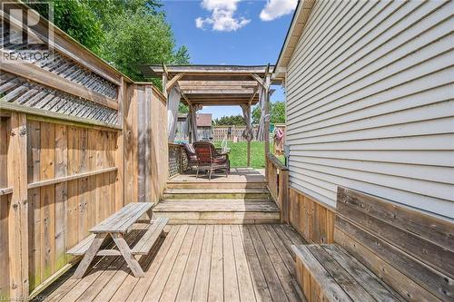 Multi-level wood deck featuring a built-in bench, wood privacy fencing with lattice accents, and a covered pergola area - 24 Byton Lane, Cambridge, ON 