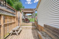 Multi-level wood deck featuring a built-in bench, wood privacy fencing with lattice accents, and a covered pergola area - 