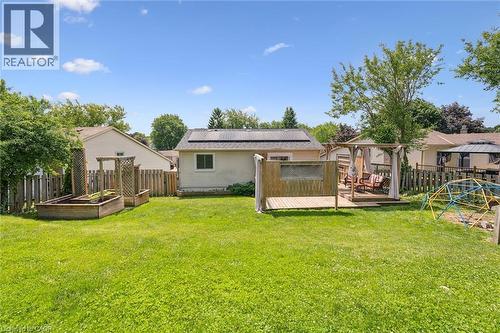 Expansive backyard featuring a green lawn, wood deck with a gazebo, and two raised garden beds - 24 Byton Lane, Cambridge, ON 