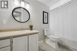 Bathroom featuring a single vanity with built-in cabinetry, a rectangular undermount sink, and a light-toned countertop - 