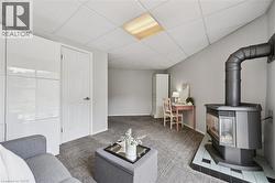 Living area featuring a floor-to-ceiling storage system, carpeted flooring, and a corner-installed gas fireplace with a tiled hearth - 