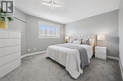 Spacious room featuring light gray walls, plush gray carpeting, and white baseboards - 