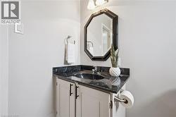 Corner vanity featuring a black stone countertop with an integrated sink and chrome faucet - 