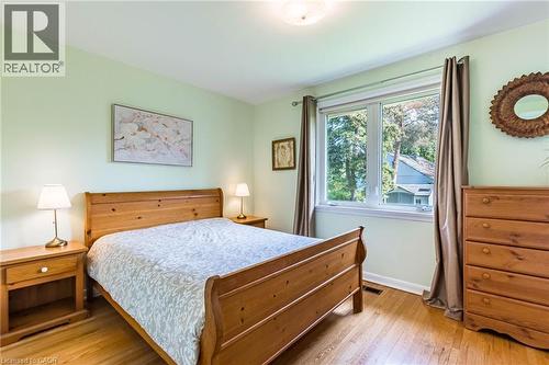 Bedroom featuring hardwood flooring, a large window, a ceiling-mounted light fixture, and light-toned wall paint - 1293 Daimler Road, Mississauga, ON 