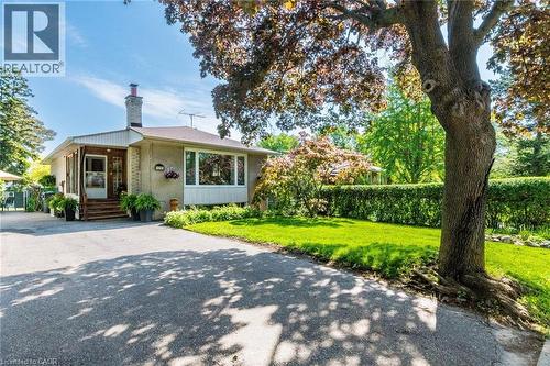 Gray stucco exterior with a prominent front window and a stone chimney - 1293 Daimler Road, Mississauga, ON 