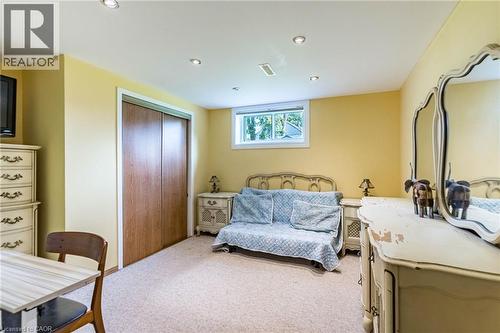 Carpeted interior space featuring a double-door closet with wood-finish panels, recessed ceiling lighting, and a single window - 1293 Daimler Road, Mississauga, ON 