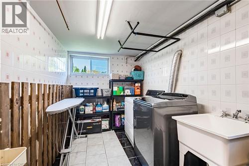 Utility room featuring a window, tiled walls, and a utility sink - 1293 Daimler Road, Mississauga, ON 