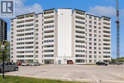 Multi-story building featuring a light-colored exterior and multiple balconies with white railings - 