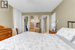 Neutral-toned bedroom featuring vertical blinds, two doorways, and light-colored walls - 