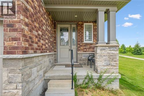 Brick exterior with stone accents, a covered front porch, and a light-colored entry door with decorative glass - 153 Rivertrail Avenue, Kitchener, ON - Outdoor