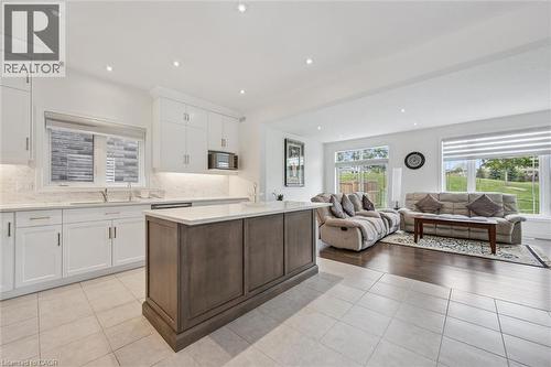 Open-concept kitchen and living area featuring white cabinetry, a central island with a lighter countertop, recessed lighting, and tile flooring - 153 Rivertrail Avenue, Kitchener, ON - Indoor