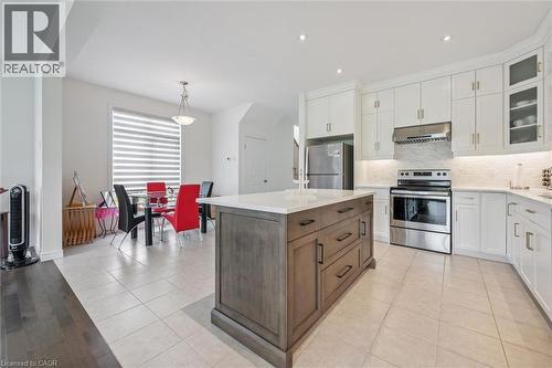 Contemporary kitchen featuring a large center island with a white countertop, white upper and lower cabinetry, and stainless steel appliances - 153 Rivertrail Avenue, Kitchener, ON - Indoor Photo Showing Kitchen With Upgraded Kitchen