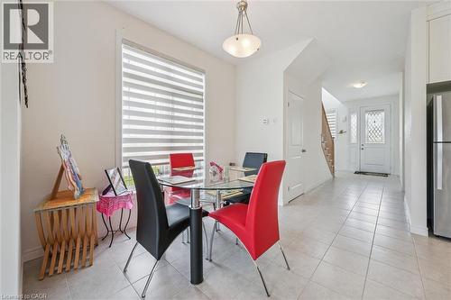 Open-concept dining area featuring light-toned tile flooring and a contemporary pendant light fixture - 153 Rivertrail Avenue, Kitchener, ON - Indoor Photo Showing Dining Room