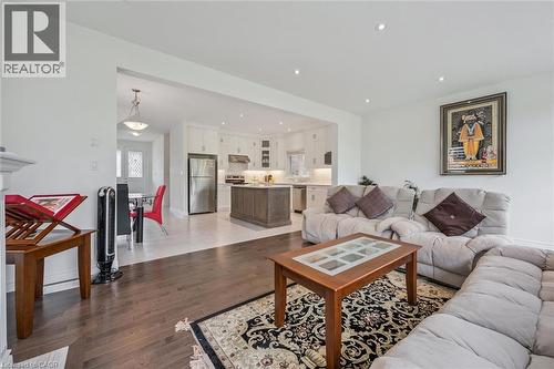 Open-concept living area featuring dark wood-finish flooring, recessed lighting, and a white fireplace mantel - 153 Rivertrail Avenue, Kitchener, ON - Indoor Photo Showing Living Room