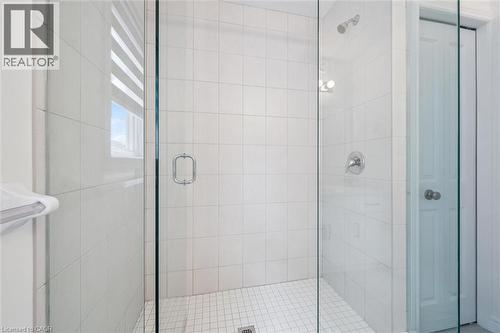 Glass-enclosed shower featuring white wall tiling, a tiled floor, and chrome fixtures - 153 Rivertrail Avenue, Kitchener, ON - Indoor Photo Showing Bathroom