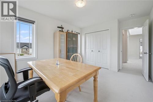 Bright room featuring a window with a roller shade, light-toned wall-to-wall carpeting, and a built-in bi-fold closet - 153 Rivertrail Avenue, Kitchener, ON - Indoor Photo Showing Dining Room