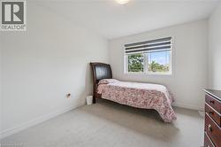 Bright room featuring light-toned carpeting and a window with horizontal blinds - 