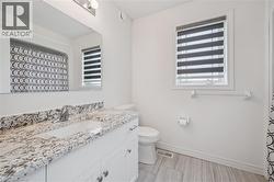 Bathroom featuring a white vanity with a patterned countertop and an undermount sink - 