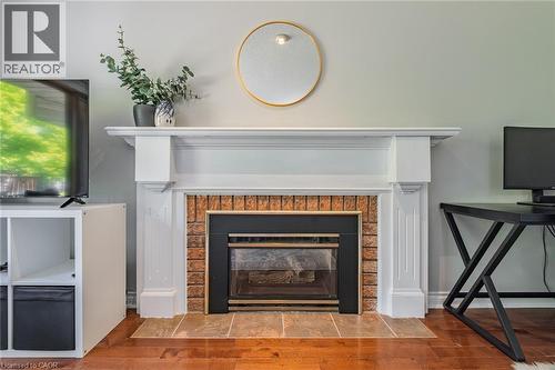 Fireplace featuring a white mantel, brick surround, and a tiled hearth - 141 Lynndale Road, Simcoe, ON 