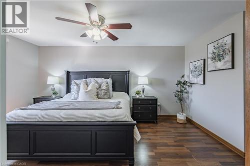 Spacious bedroom featuring wood-finish flooring, a ceiling fan with integrated lighting, and neutral wall tones - 141 Lynndale Road, Simcoe, ON 