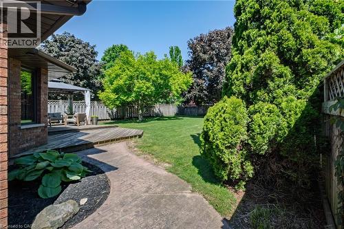 Expansive backyard featuring a lush lawn, mature trees, and a wooden deck - 141 Lynndale Road, Simcoe, ON 