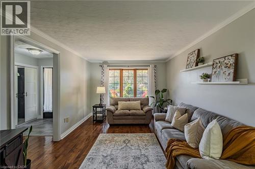 Living area featuring wood-finish flooring, crown molding, and light gray wall paint - 141 Lynndale Road, Simcoe, ON 