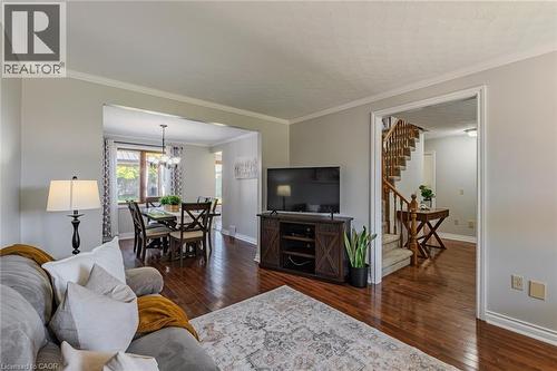 Open-concept living area featuring wood-finish flooring, light gray wall paint, and white crown molding - 141 Lynndale Road, Simcoe, ON 