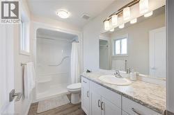 Bathroom with vanity, dark wood-type flooring, and a shower stall - 