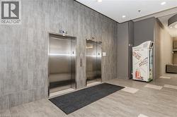 Two stainless steel elevators set within a wall of large format gray tile - 
