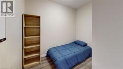 Compact interior space featuring wood-finish flooring, light neutral wall paint, and a built-in shelving unit - 