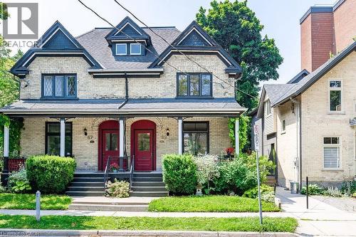 Brick exterior with dark trim and complementary red doors - 67 Ahrens Street W, Kitchener, ON 