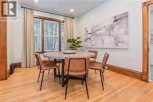 Dining area featuring wood-finish flooring, recessed lighting, and a prominent bay window with wood trim - 67 Ahrens Street W, Kitchener, ON 