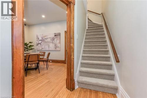 Carpeted staircase featuring a wood handrail - 67 Ahrens Street W, Kitchener, ON 