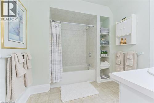 Bathroom featuring a built-in tub and shower combination with a tiled surround - 67 Ahrens Street W, Kitchener, ON 