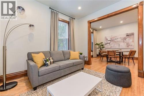 Bright living area featuring wood-finish flooring, recessed lighting, and a wide cased opening to a separate dining space - 67 Ahrens Street W, Kitchener, ON 