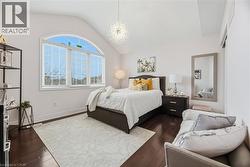 Bedroom featuring vaulted ceiling, dark wood-style flooring, and a chandelier - 