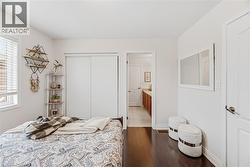 Bedroom with dark wood-type flooring, a closet, and ensuite bathroom - 