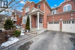 Traditional-style house with asphalt driveway, brick siding, and a garage - 