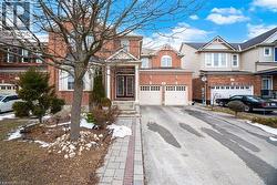 View of front of house featuring asphalt driveway, brick siding, and an attached garage - 